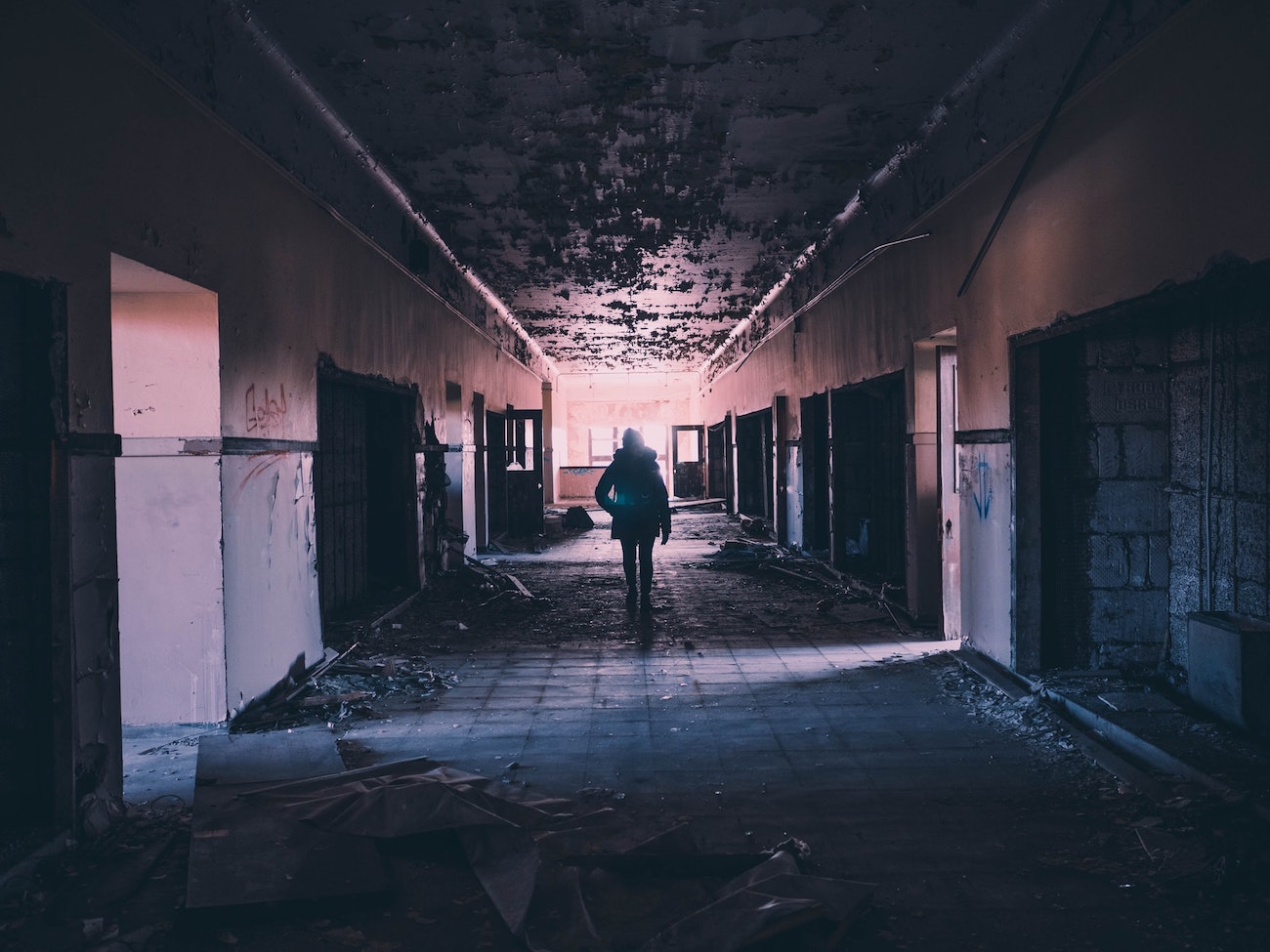 Person walking down hallway of abandoned building